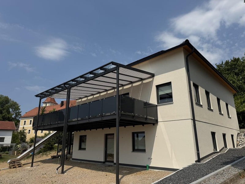 Fertig montierte Terrassenüberdachung mit Glasdach und anthrazitfarbenem Geländer