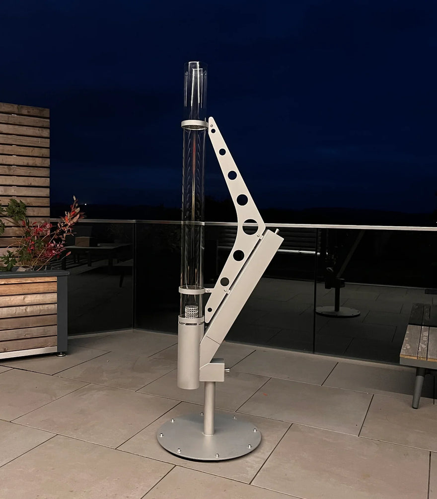 Moderne Pellet Feuersäule Heizpilz aus Metall auf Terrasse bei Nacht
