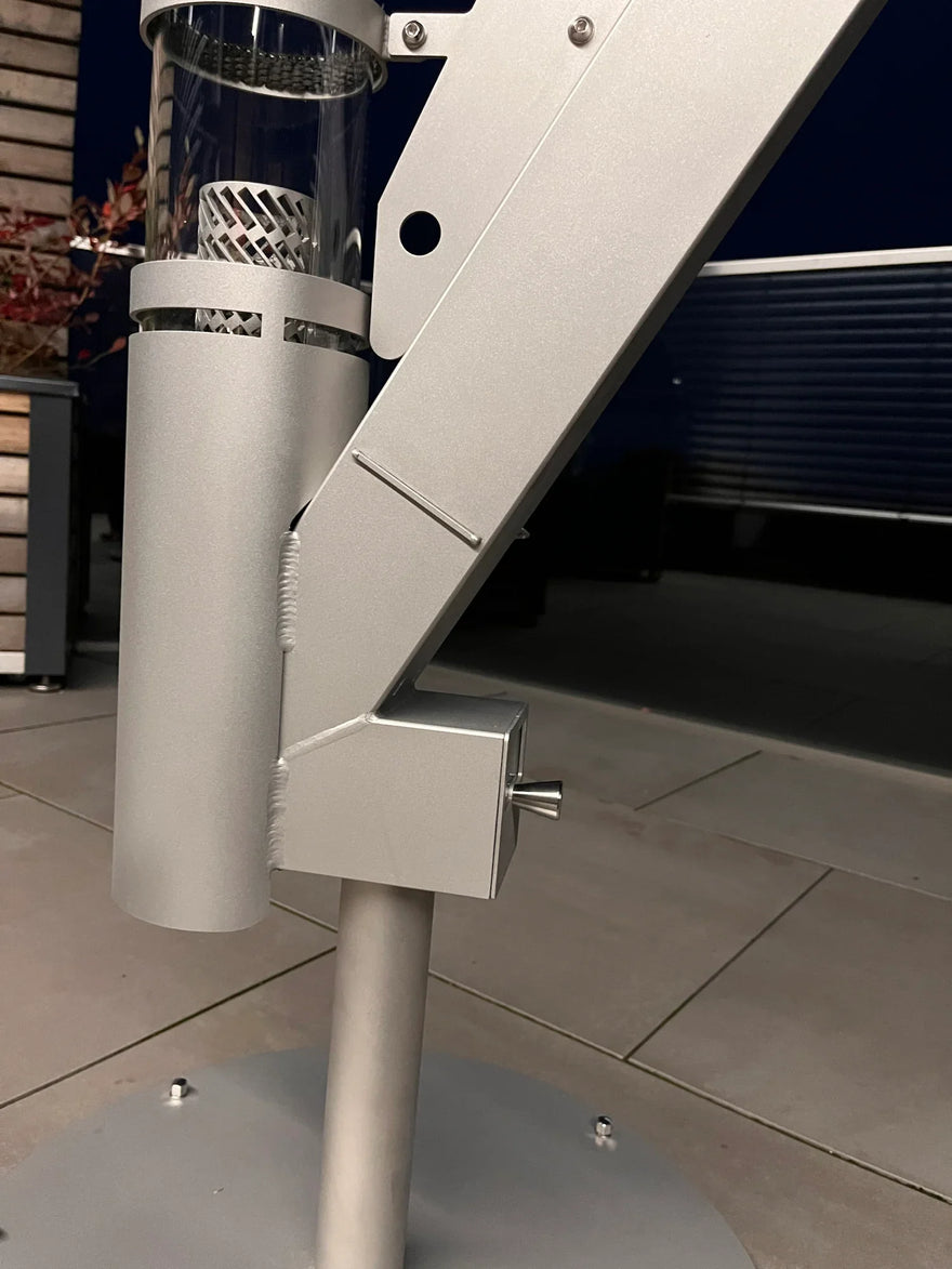 Detailansicht Edelstahlsäule eines Pellet-Feuerofens auf Terrasse bei Nacht