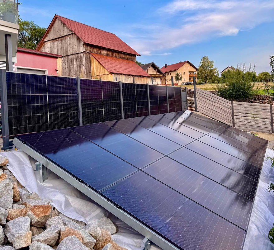 Photovoltaik-Solarzaun und Solarmodule im Garten eines Wohnhauses, nachhaltige Energie