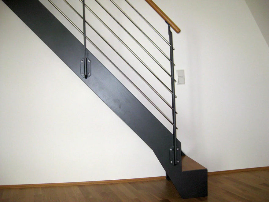 Moderne Innentreppe aus Metall mit Handlauf und Holzstufen, Metallgeländer, weißer Wand
