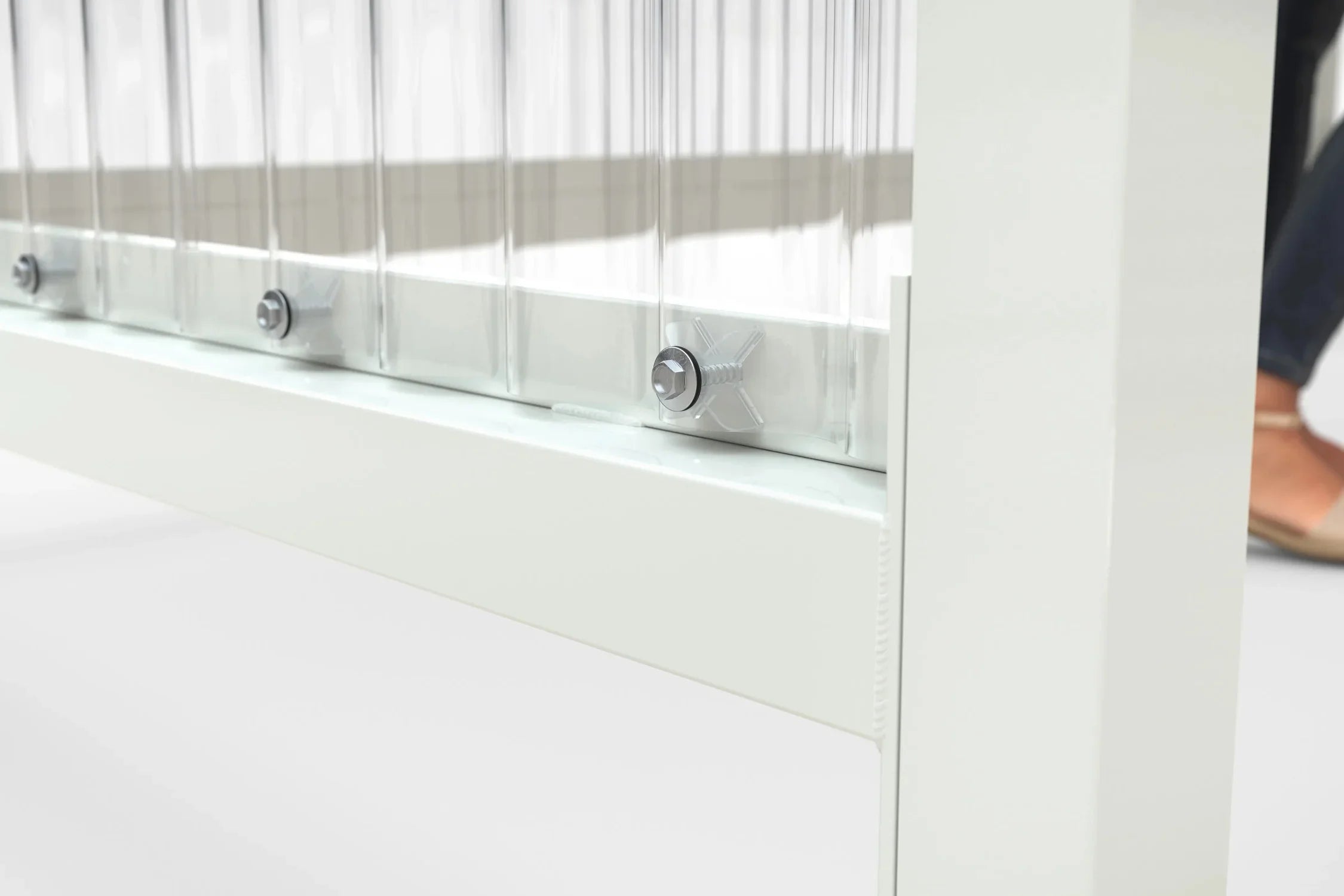 Detail des unteren Wandanschlusses mit Kalottenschrauben zwischen Wellpolycarbonat-Wand und Rahmenprofil, Raucherunterstand Jena Maxi RAL 9002 grauweiß